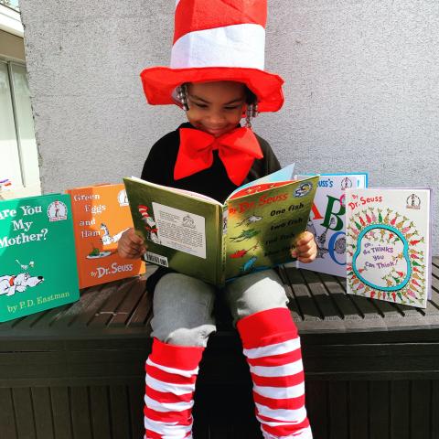 Child reading in Cat in the Hat costume. 