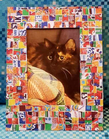 Mosaic frame of tile cereal boxes with a picture of long-haired tortoiseshell cat.