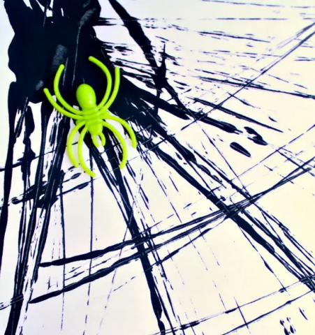 Spiderweb made from black paint with neon green spider