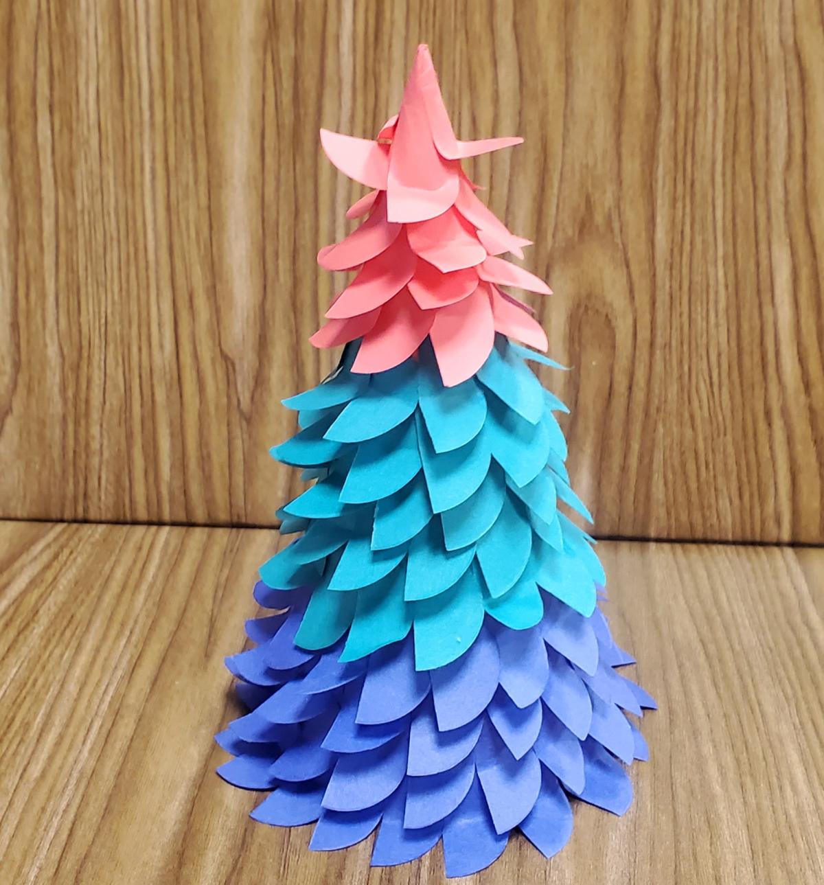 Evergreen shaped paper craft with blue, teal and pink needles.