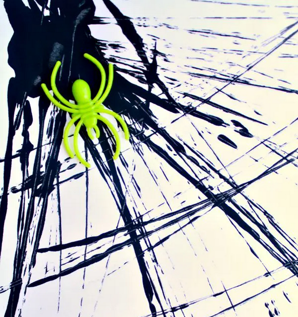 Spiderweb made from black paint with neon green spider